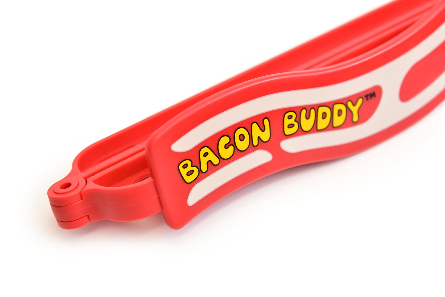 The Bacon Buddy clip, a 13 inch (35cm) long, red wavy bacon shaped plastic food packaging clip. Has printed wavy text in yellow saying 'Bacon Buddy' and wavy cream strips to look like bacon. Close up photo of one end with logo, photographed on a plain bright white background