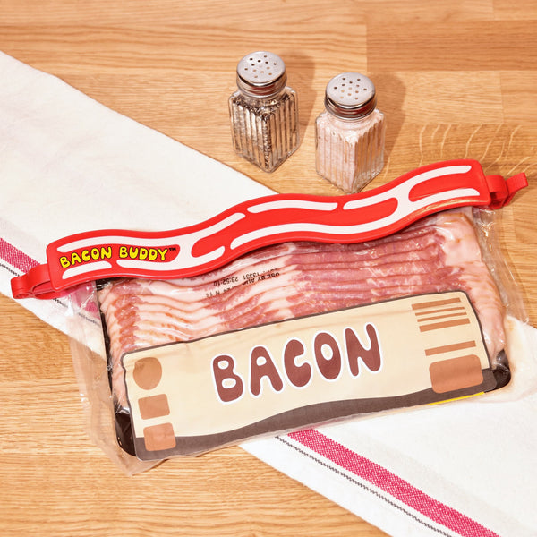 Red Bacon Buddy Clip clamped onto a bacon package on a kitchen counter to keep it fresh